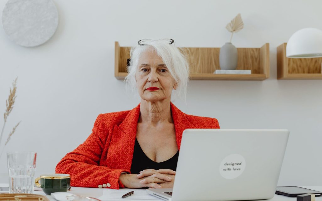 Mujer de más de 60 años trabajando con el portátil en su escritorio