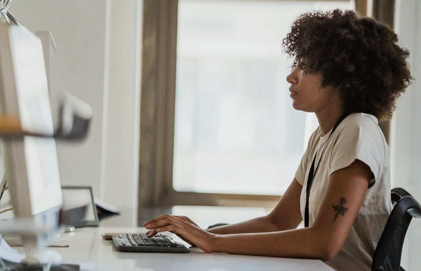 Mujer trabajando frente al ordenador, vista de perfil
