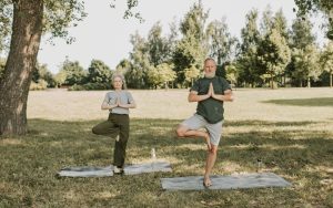 Pareja de más de 60 años haciendo ejercicios de equilibrio en un parque