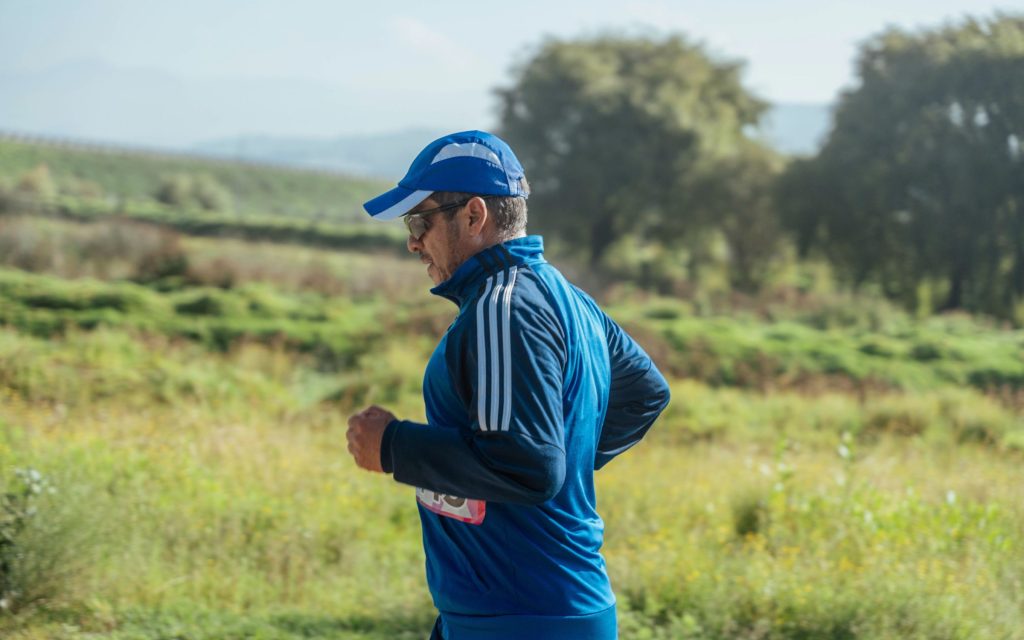 Hombre de mediana edad corriendo por un camino de campo