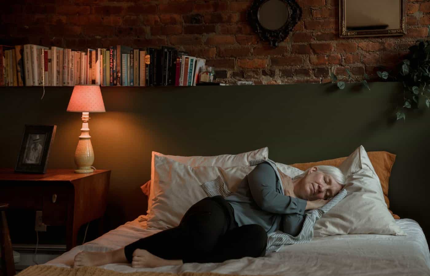 Mujer mayor durmiendo de lado en una habitación acogedora